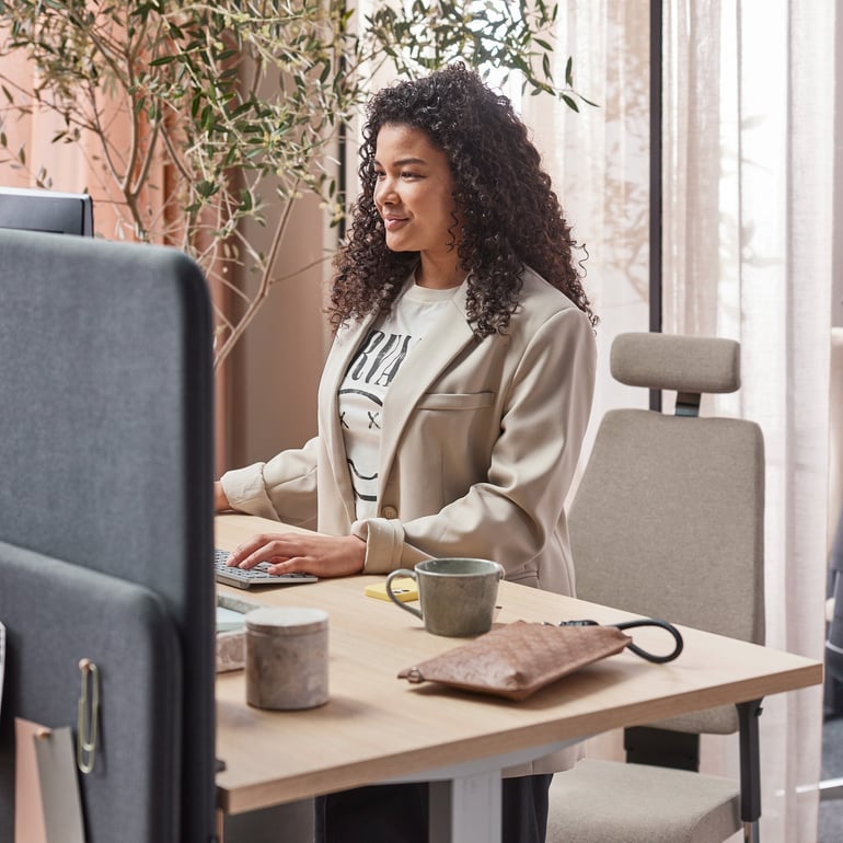 an office worker sitting at her desk in front of the computer