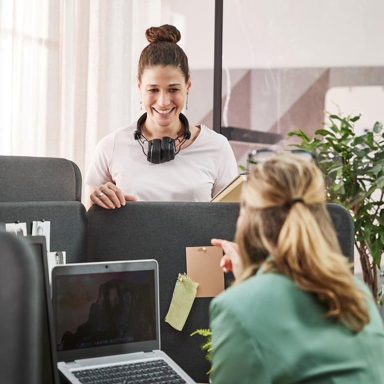 two colleagues chatting over the office desk