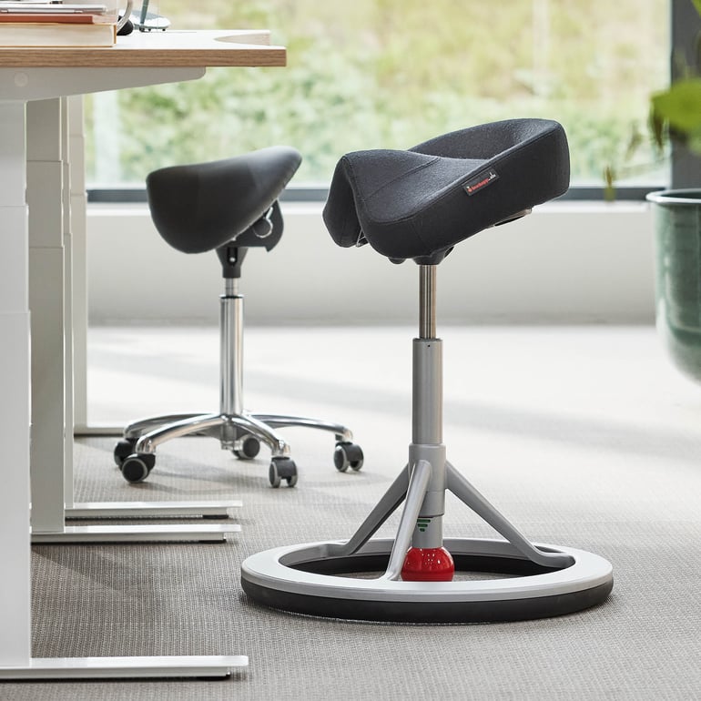 Ergonomisk pall designad för kontorsbruk, med böjd sittdel och justerbar höjd.