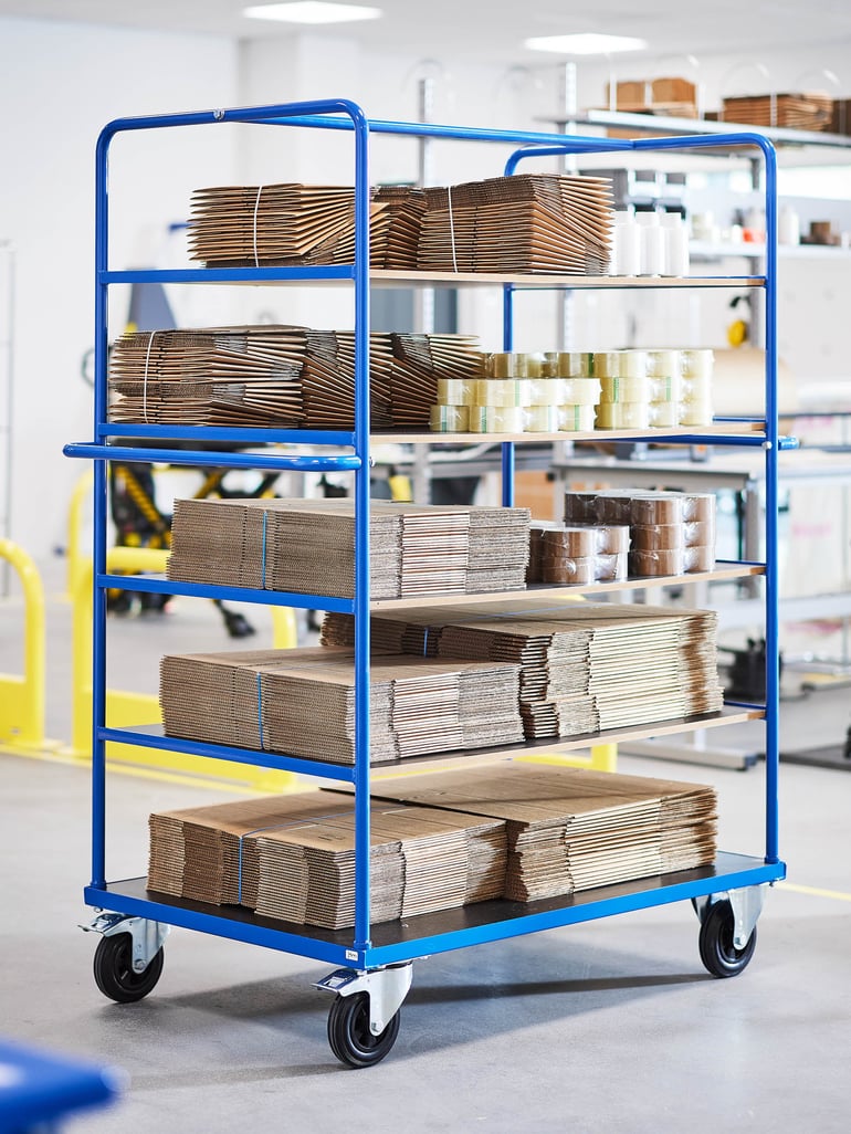 Hyllvagn fylld med kartonger, designad för enkel transport i verkstäder.
