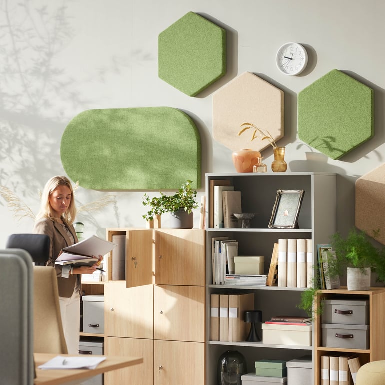 Person standing close to a cabinet in an office environment.