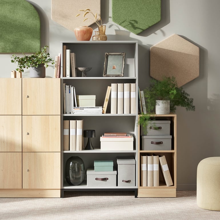 Bokhylla med hyllor som visar böcker och små växter, avsedd för kontorsbruk.