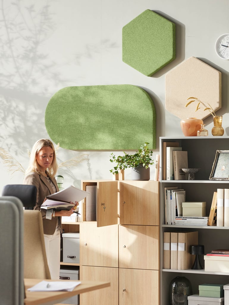 Person standing close to a cabinet in an office environment.