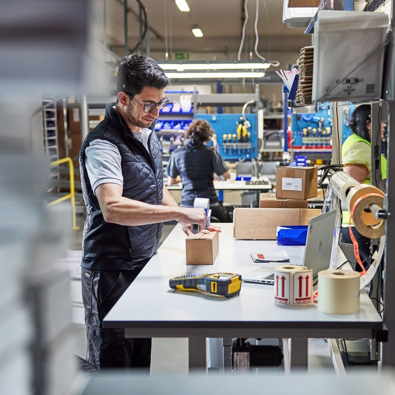 a person focusing on his task at a packing station