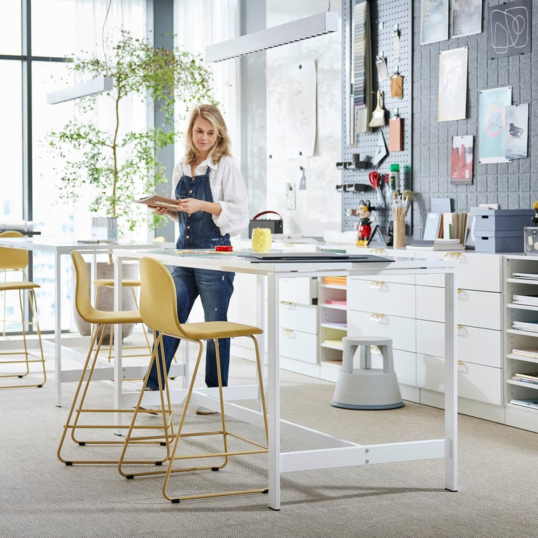Eine Frau steht im Büro an ihrem Schreibtisch