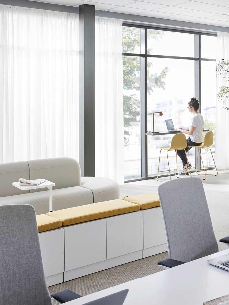 Eine Frau sitzt im Büro und arbeitet an ihrem Laptop