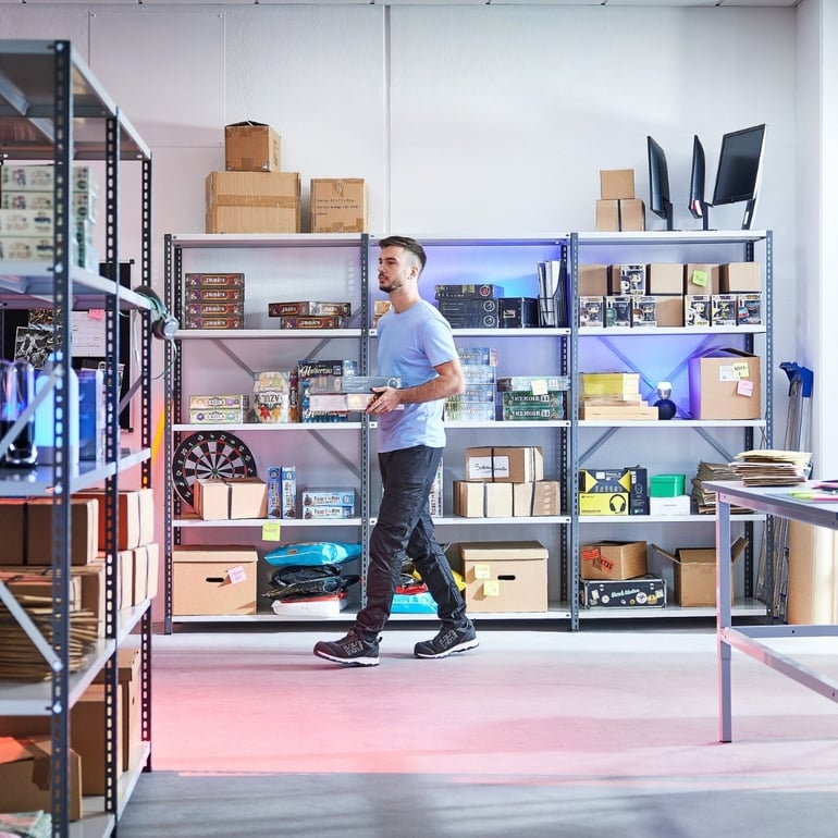 Muž ve skladu se skladovými regály