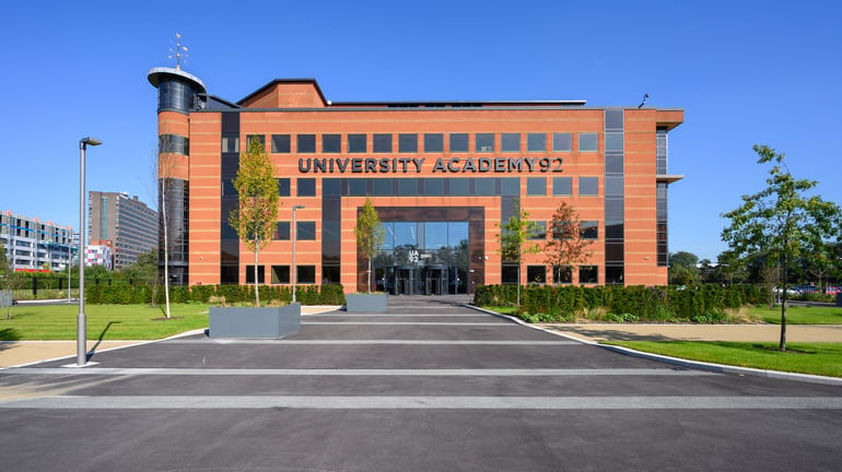 Front view of University Academy 92 (UA92) building, showcasing its modern red-brick facade.