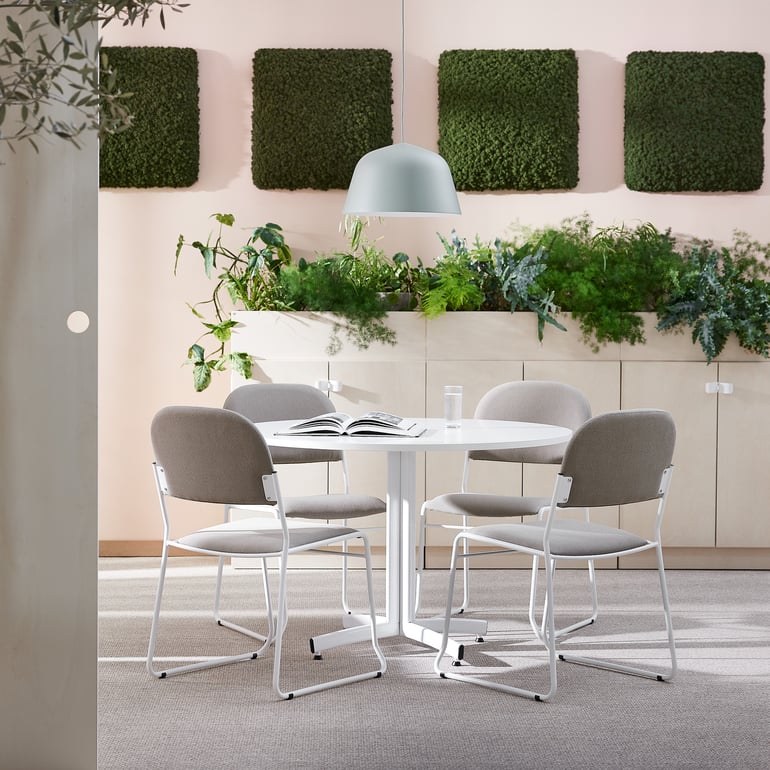 conference table with live plant sound panels and artificial plants against the wall