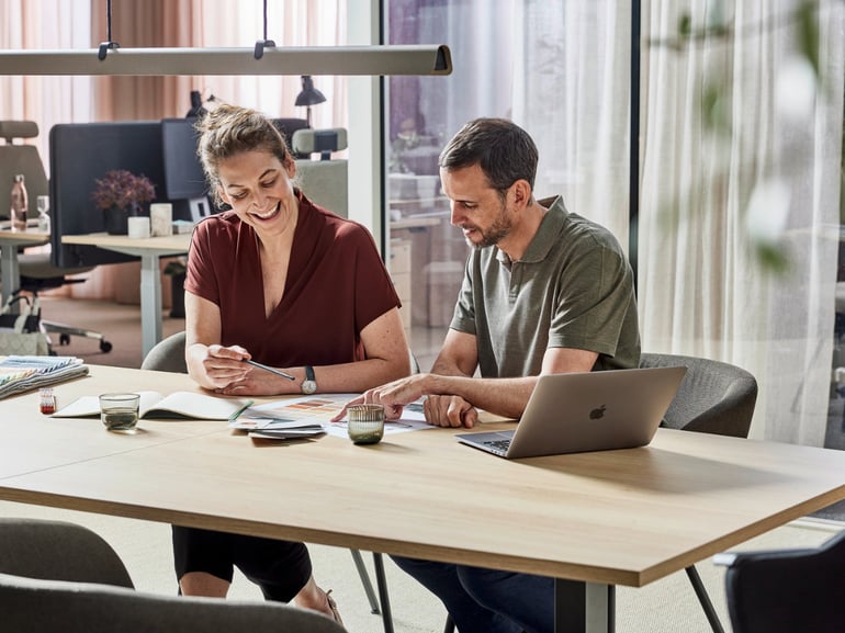 To personer som sitter ved et arbeidsbord
