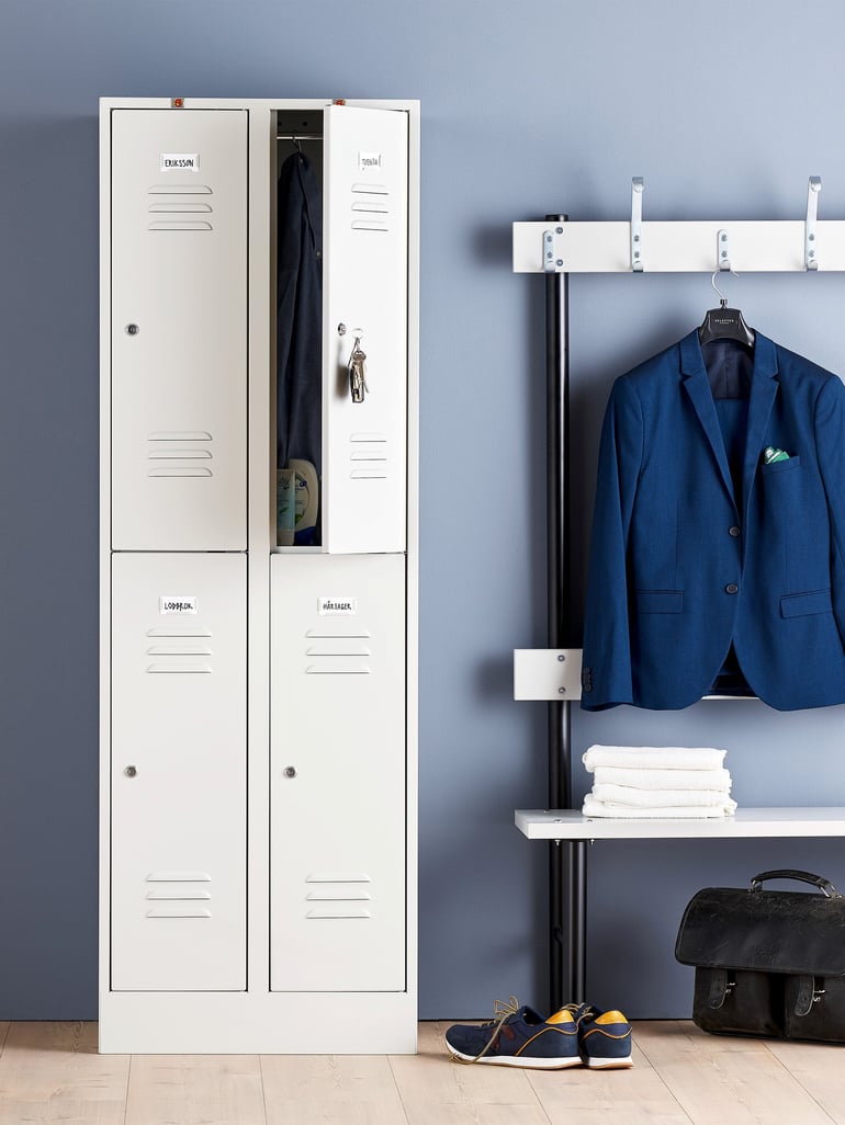 Small compartment cabinet with four doors next to a bench with hooks