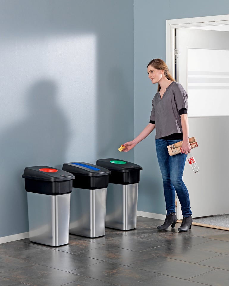 Girl recycles lunch packaging in a collection cabinet with a lid