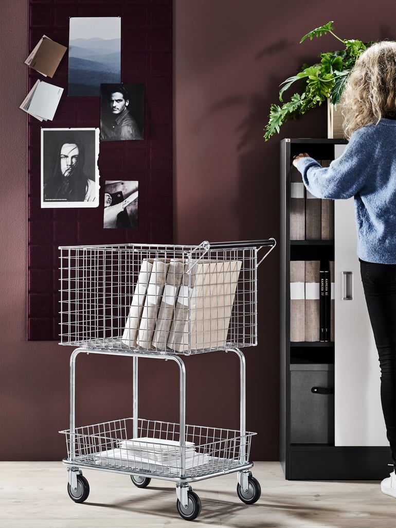 A sorting cart filled with binders in an office, in the background a bookshelf can be seen