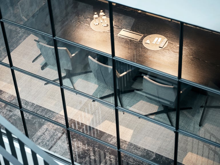 Conference room table and chairs viewed through an office window