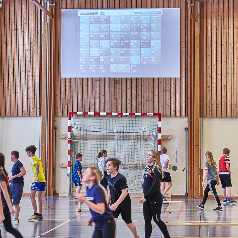 School children playing sports in school gym 