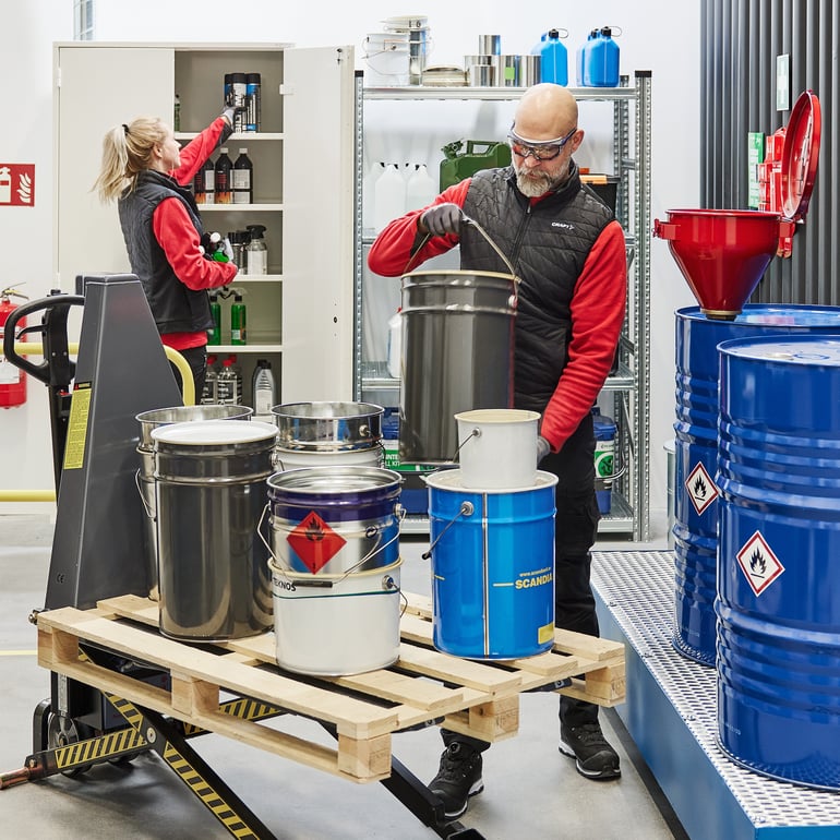 Arbeidere som håndterer farlig avfall på lageret