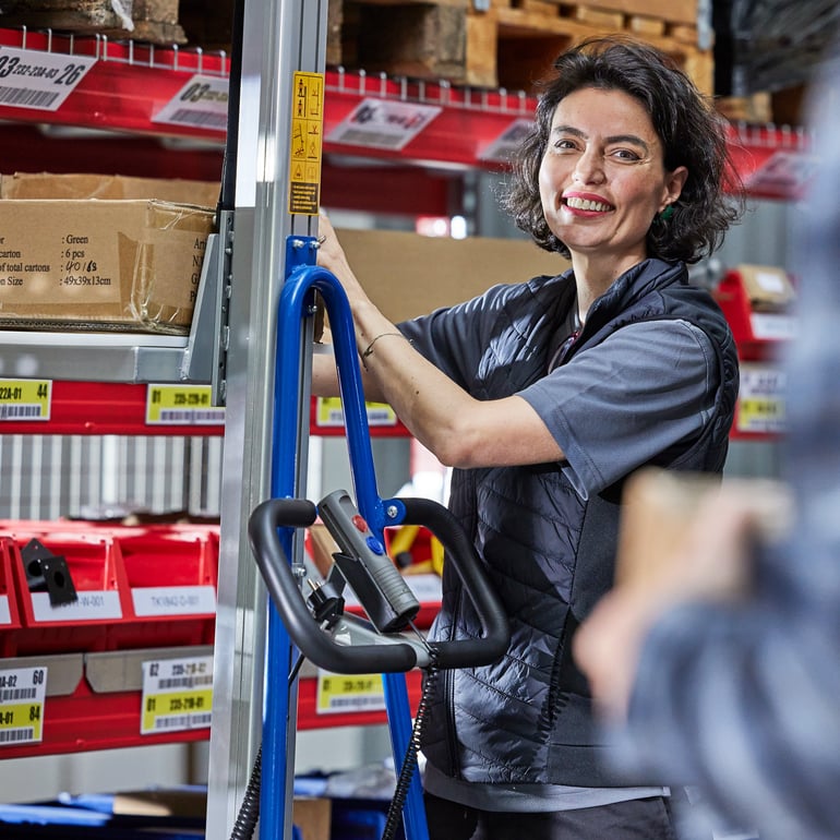Žena ve skladu se zvihacím vozíkem