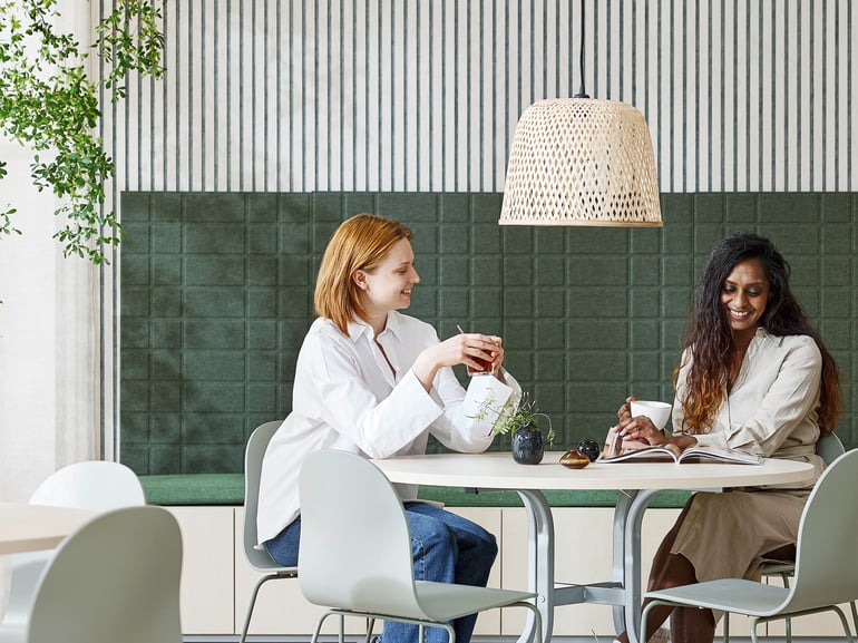 To personer sidder ved et kantinebord og taler sammen