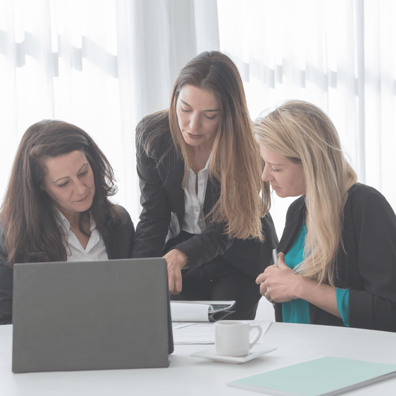 3 kolleger diskuterer på et kontor ved en computer