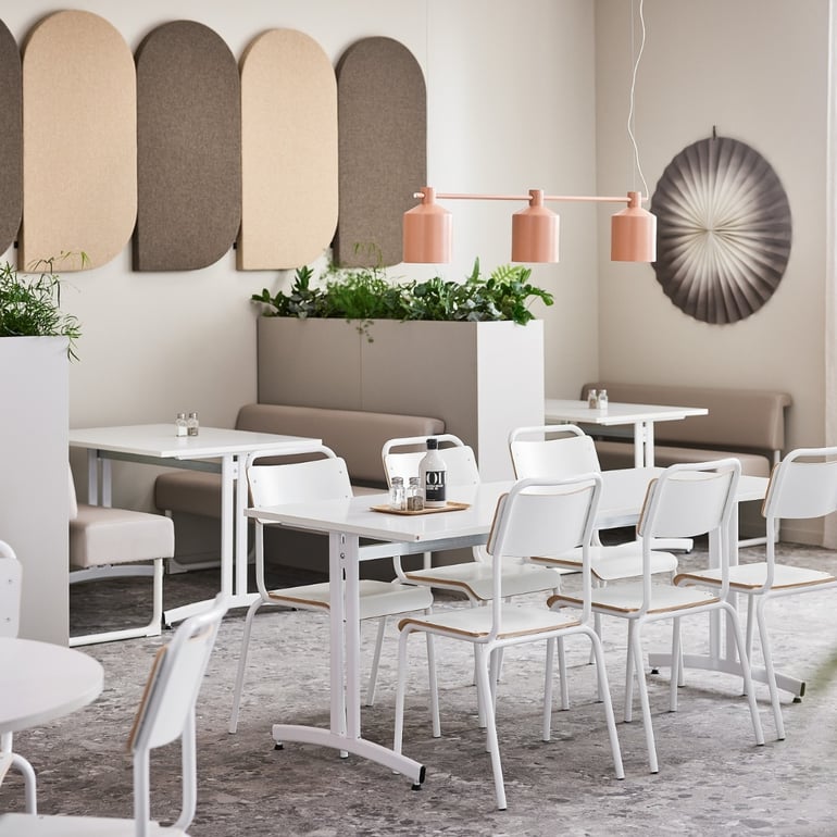 Prostředí restaurace s akustickými panely, stoly a židlemi
