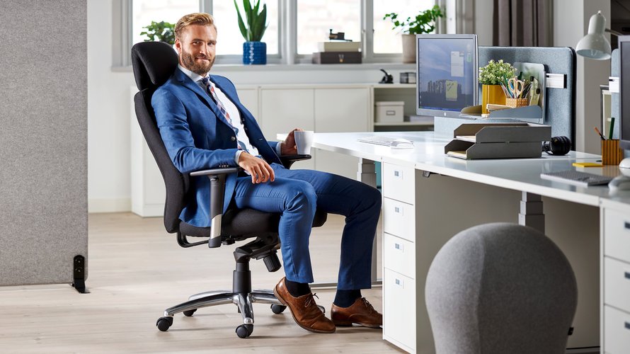 vīrietis sēž biroja krēslā