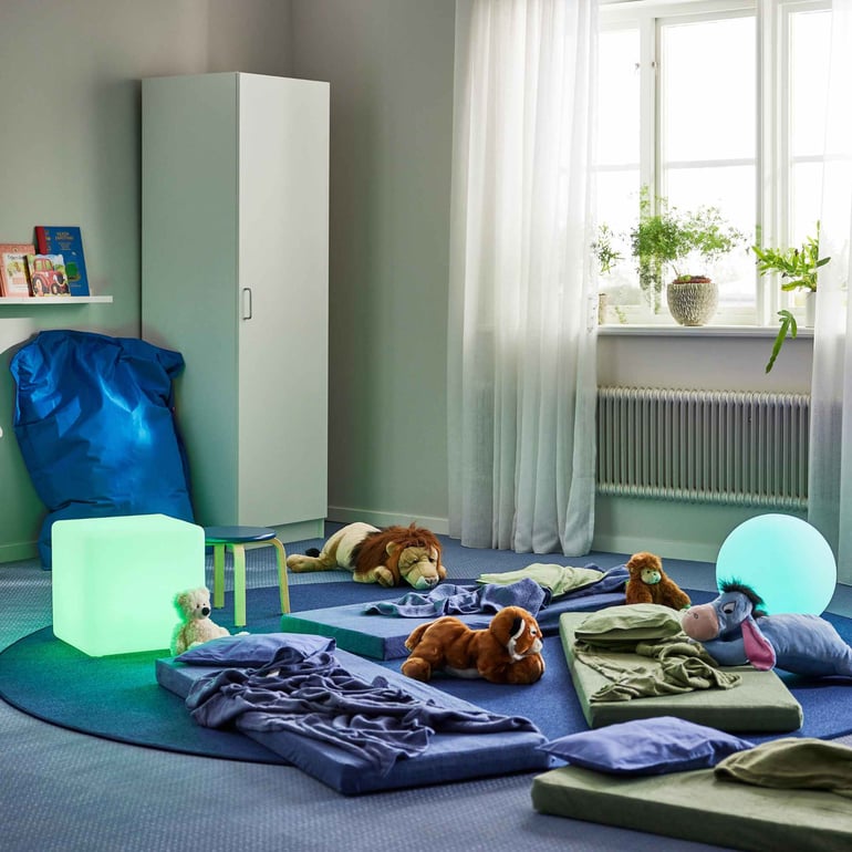 Et dejligt rum til afslapning i børnehaven med madrasser og lamper i forskellige former og farver som giver et roligt lys