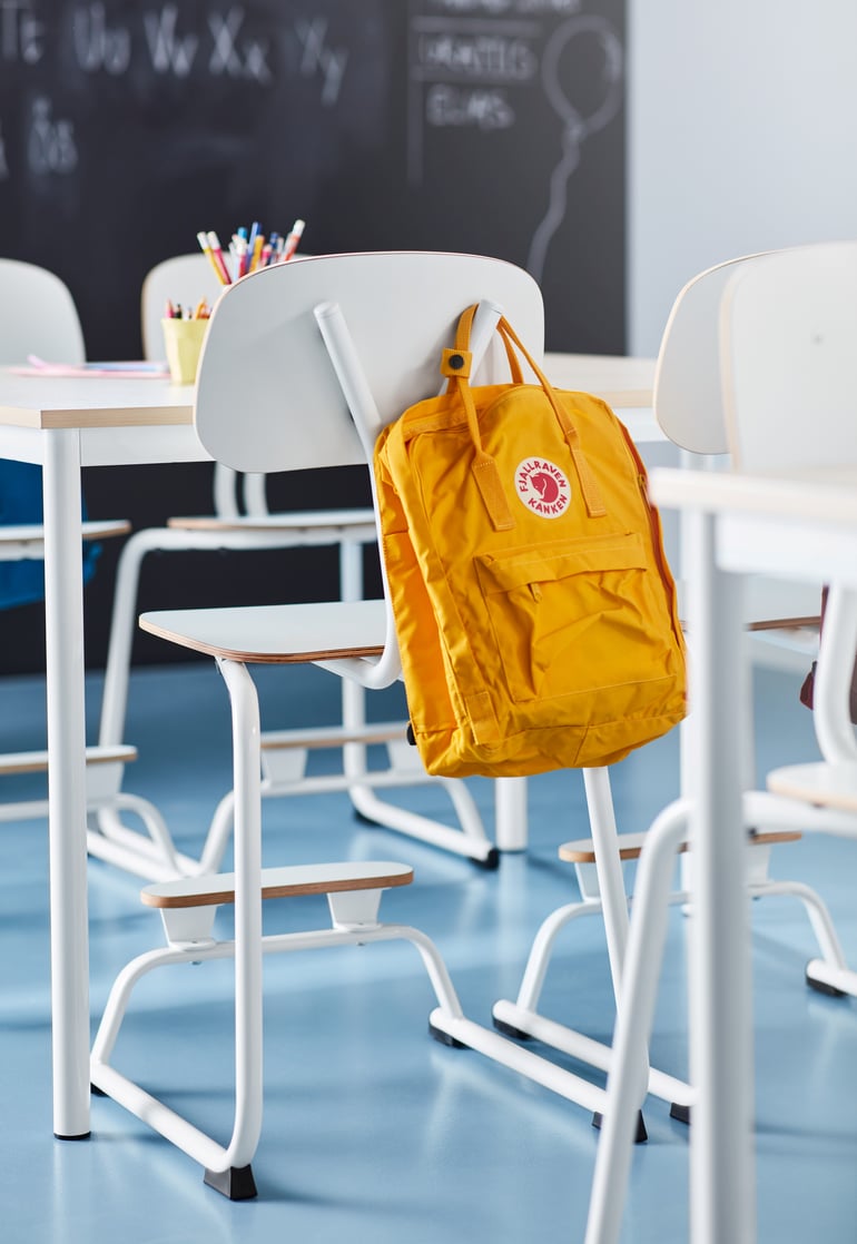 Skolestol YNGVE med en rygsæk der hænger bag på
