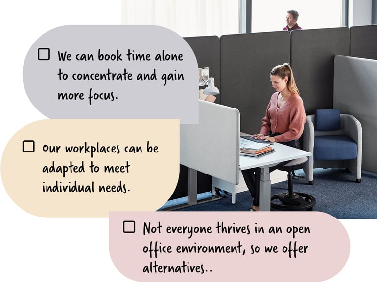 A woman sitting at a desk in a soundproof office environment