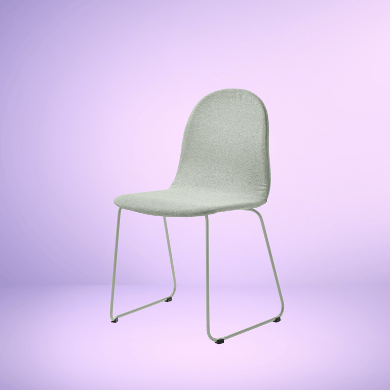 En mintgrøn stol fra AJ Produkter ved en lilla væg