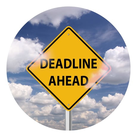Et gult skilt med teksten "deadline ahead" med blå himmel og skyer i baggrunden