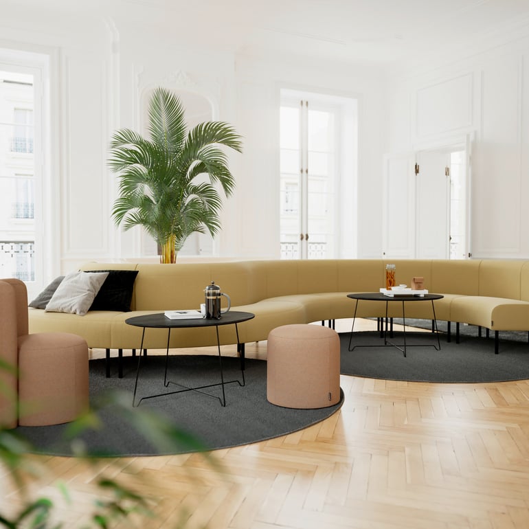 Long curved sofa with coffee tables and pouffes
