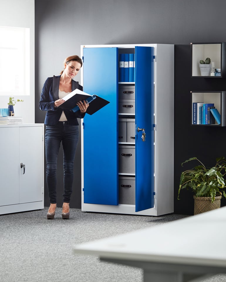 Ett förvaringsskåp med lås och blå dörrar i ett kontorsrum