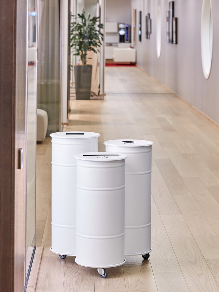 Three round waste containers in different heights with casters and differently shaped openings