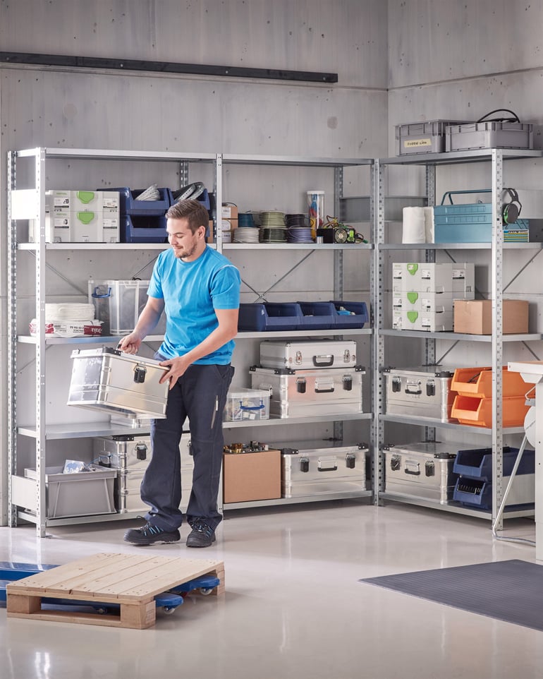 Warehouse worker moves goods from warehouse shelf