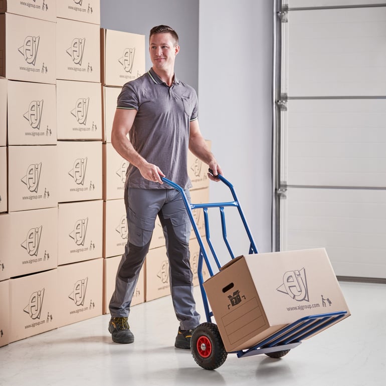 Ein Mann bewegt Kisten mit einer Transportwagen