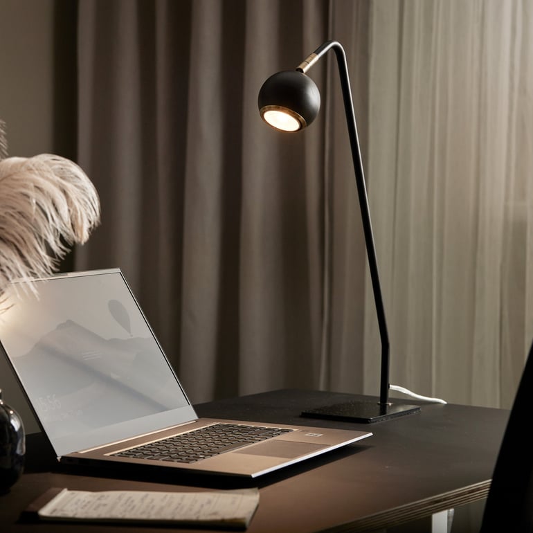 Desk lamp next to a laptop