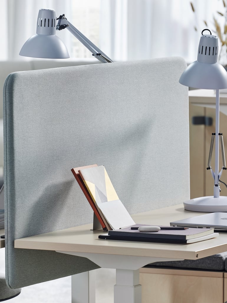 Desk with a light grey, sound absorbent desk screen