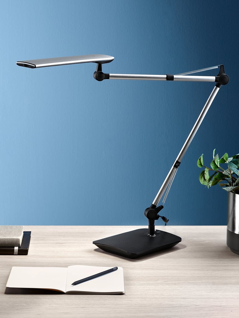 En skrivbordslampa med justerbar arm för riktat ljus