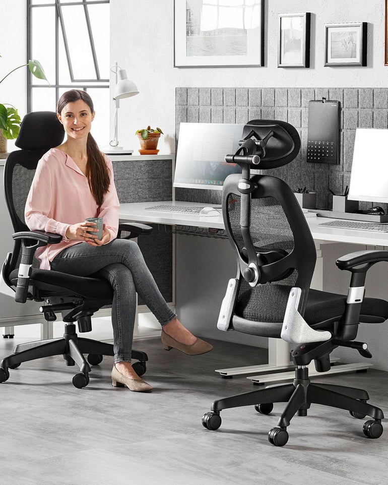 Žena sedí na ergonomické kancelářské židli a opírá si ruku o područku