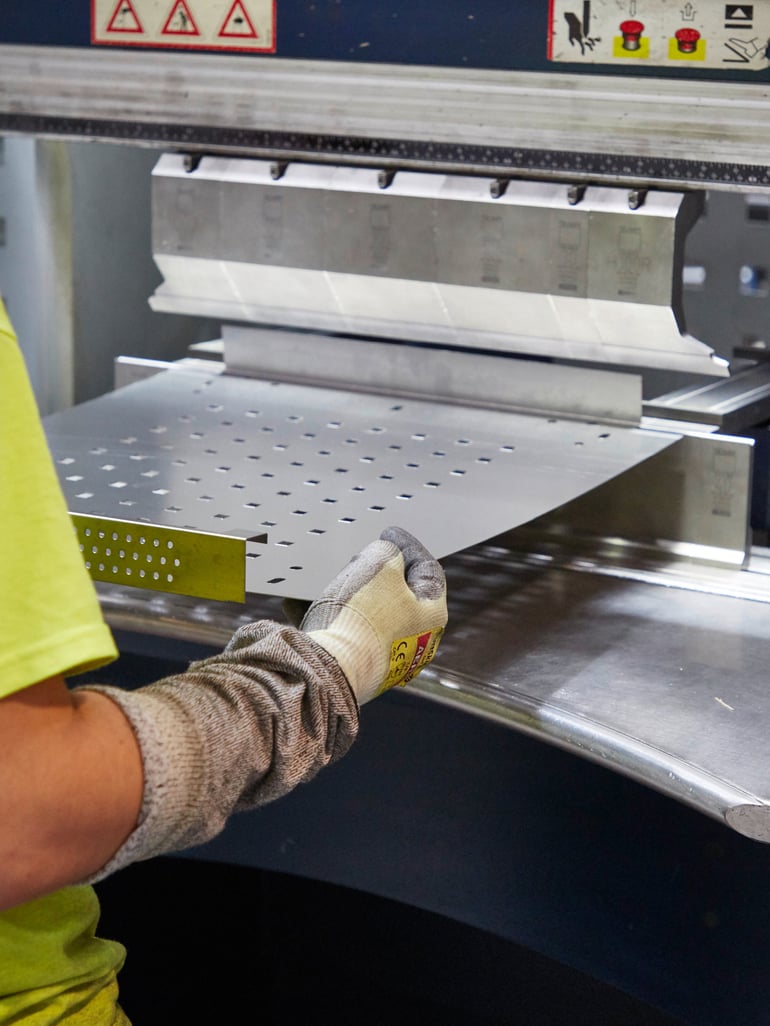 Person threading sheet steel through a machine