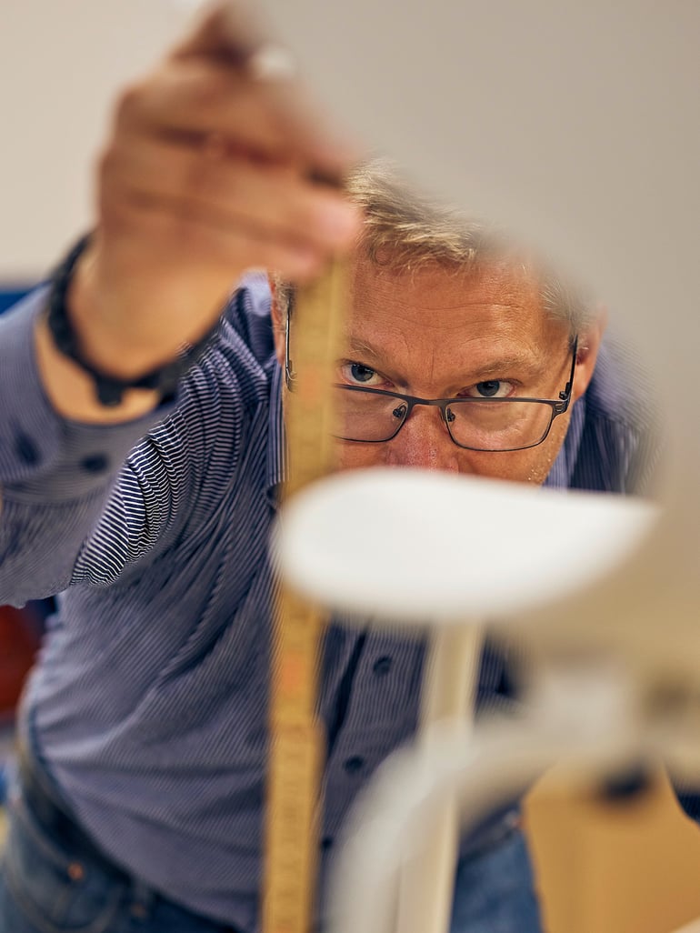 Man measuring furniture as part of quality check