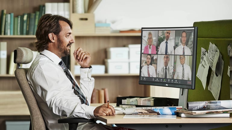 Man sitting at a desk and attending a virtual meeting