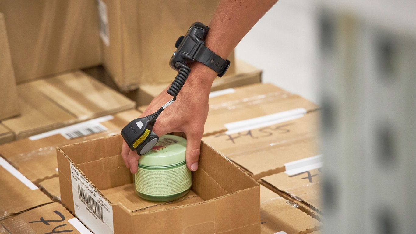 Close up of hand packing goods into box