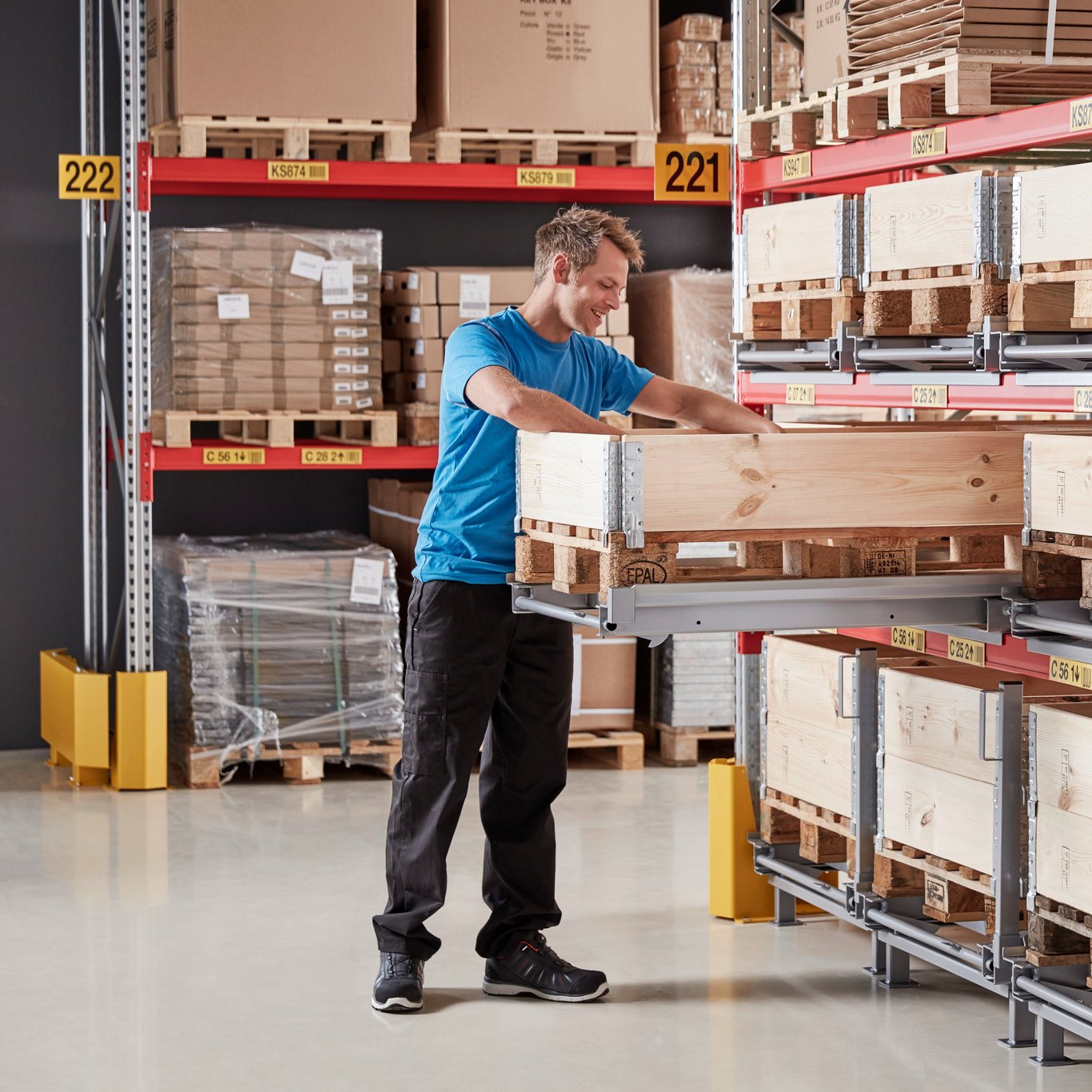 Person loading goods onto a pull-out pallet on pallet racking