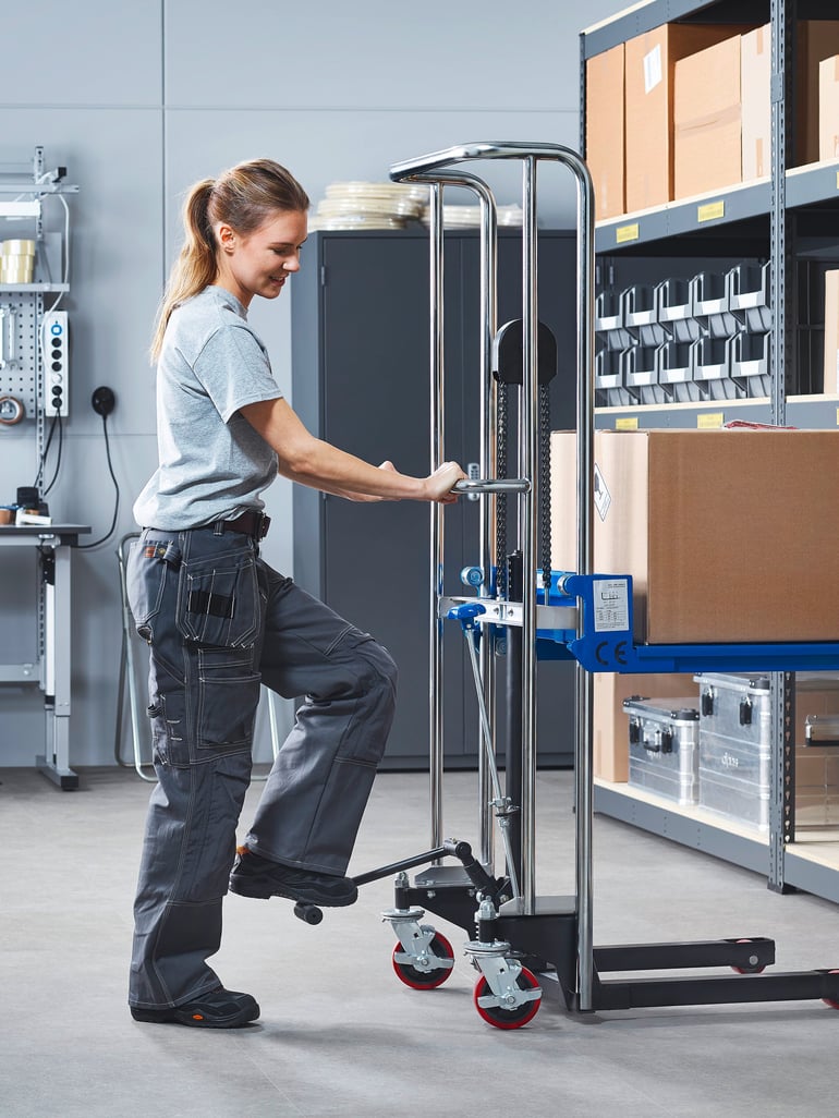 Woman using mini stacker to move boxes in warehouse