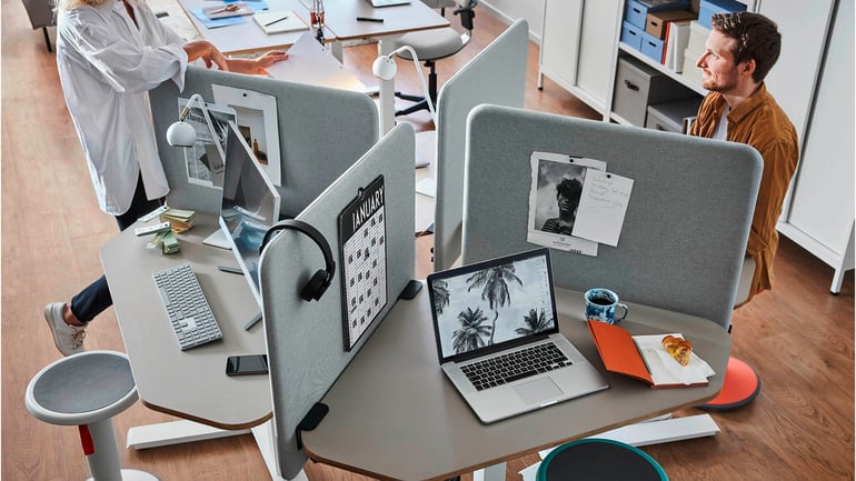 Kontormiljø med skrivebord og skjermvegger