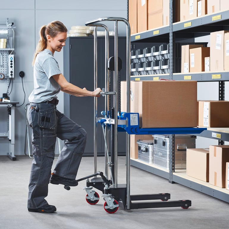 Woman using mini stacker to move boxes in a warehouse