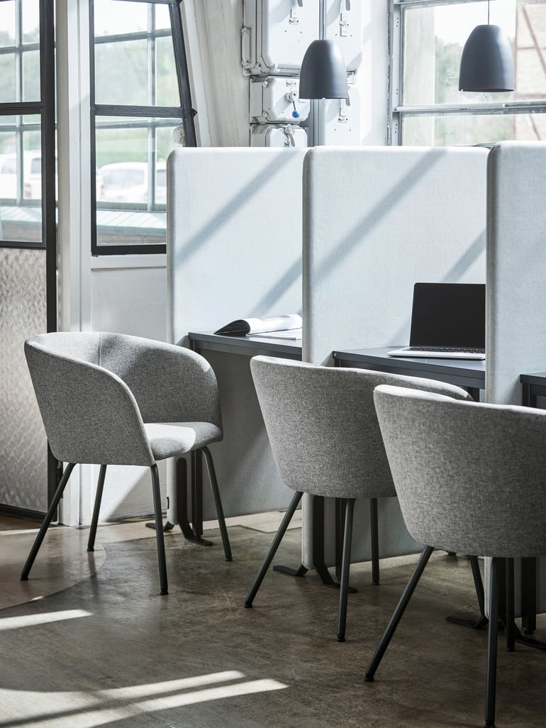 Open office with a row of deska dn chairs separated by screens