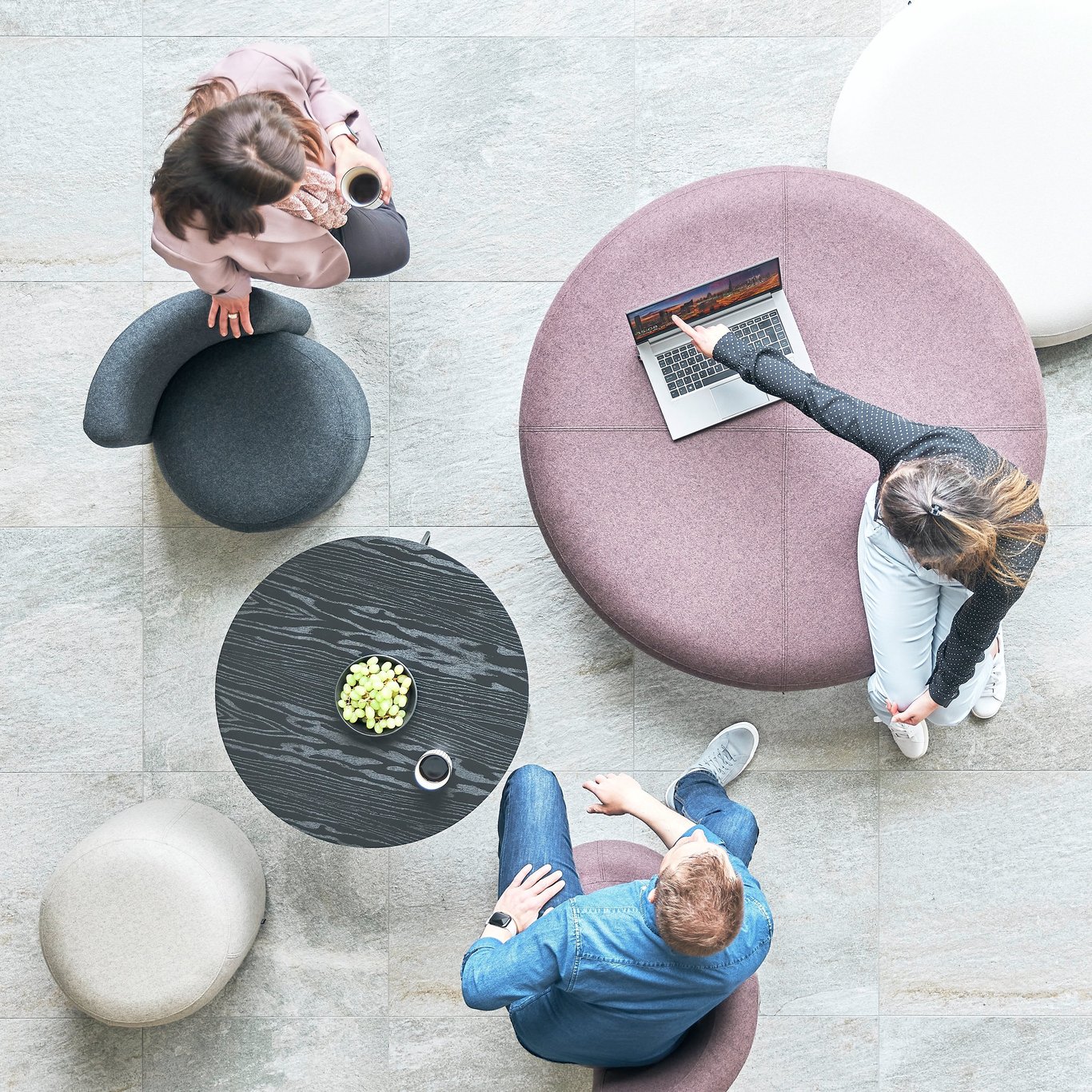 Three people sitting in a breakout space working and chatting