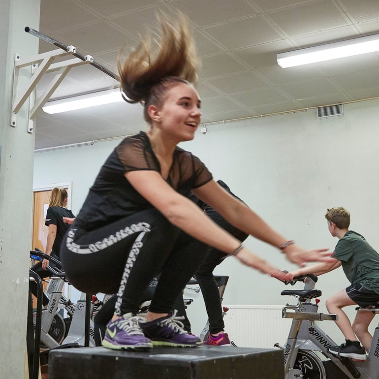 Teenage girl exercising in a gym